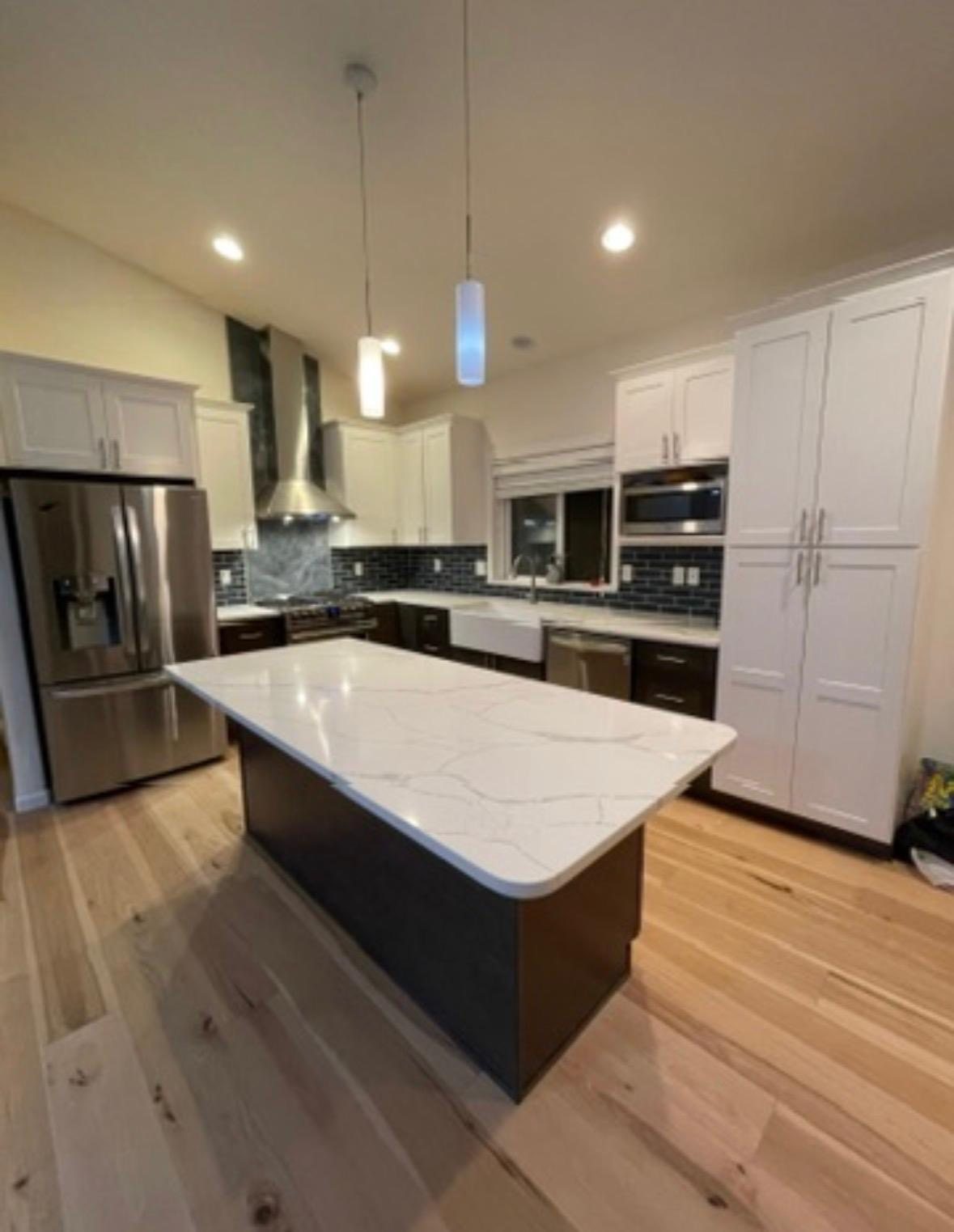 North East kitchen remodel with white quartz island, shaker cabinets, and hardwood floors