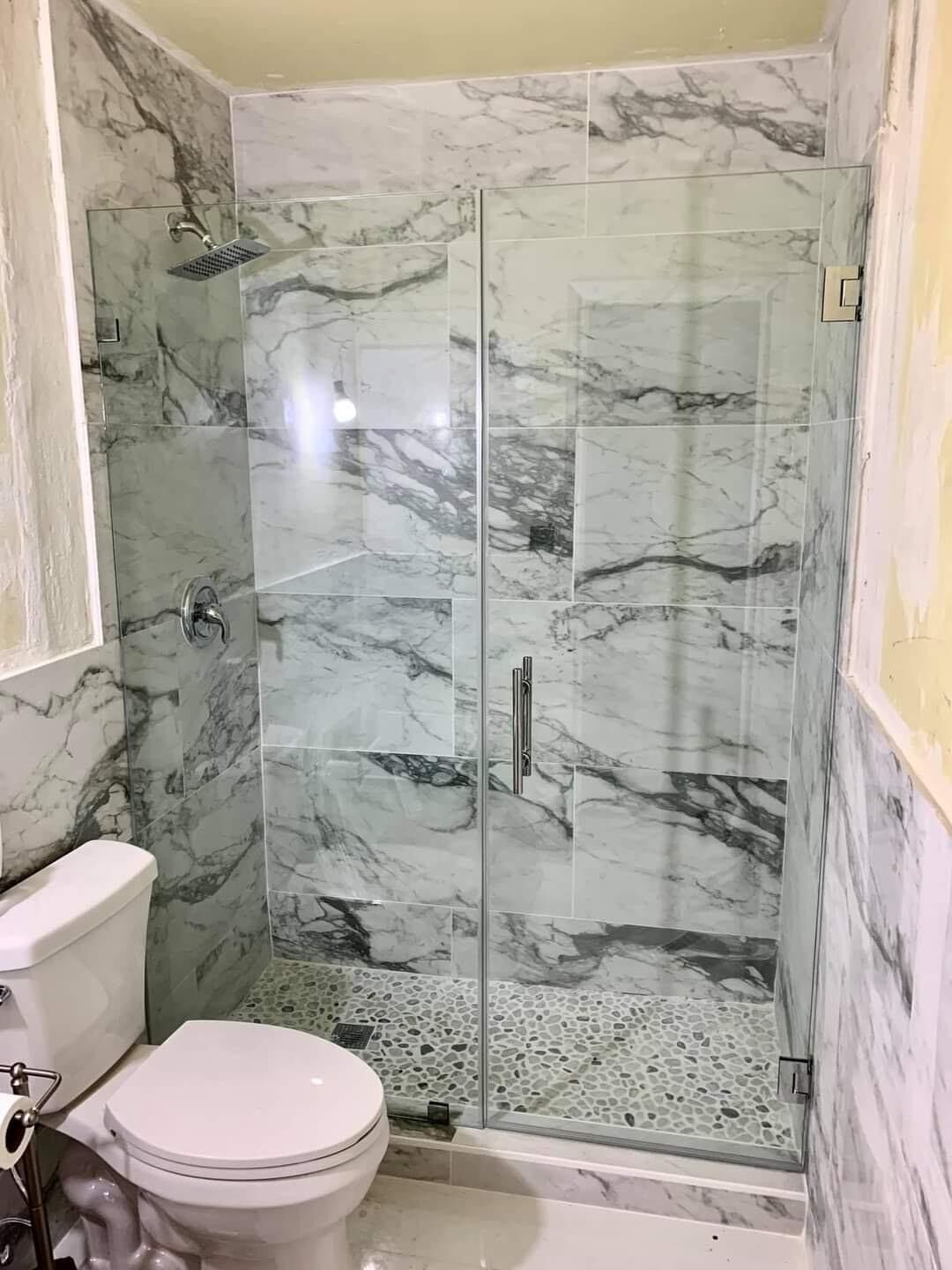 Marble-look walk-in shower with frameless glass